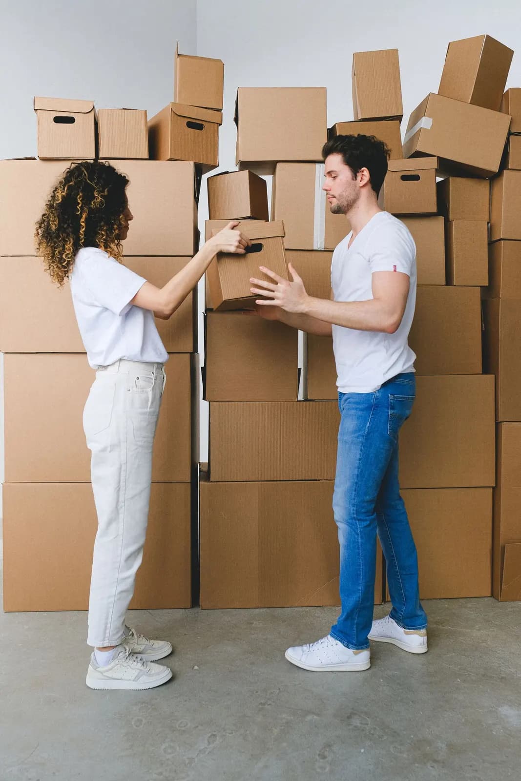 Two people carrying boxes during a move